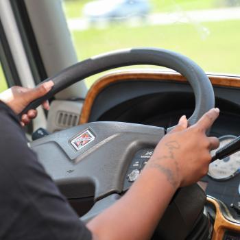 Transportation student practices driving a commercial vehicle during hands-on training.