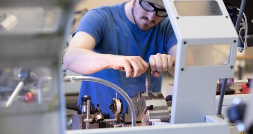 Male student uses a lathe