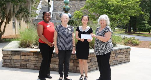 AAUW members present a check to student Vy Tran