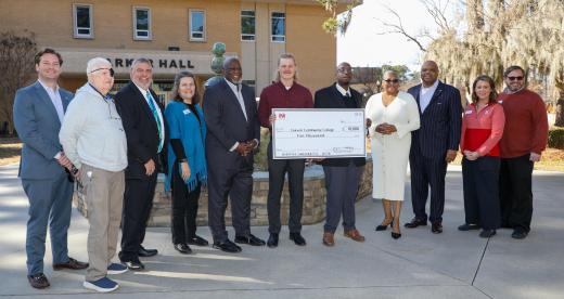 Members of the Whittenburg Foundation and Craven Community College Foundation, Health Sciences staff, and two male students post with a large check for $10,000