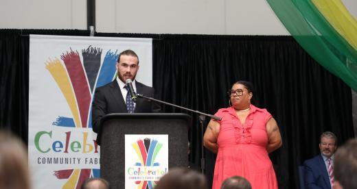 man speaks at microphone podium
