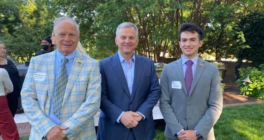 Three men stand together in suits