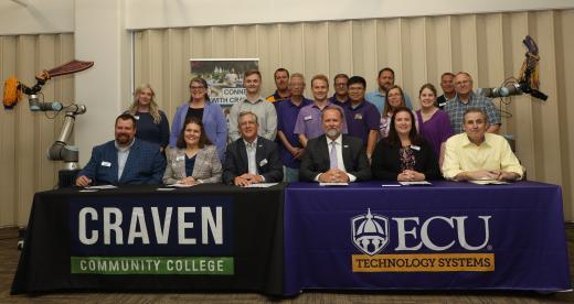 People sitting at a table with tablecloths for Craven and ECU