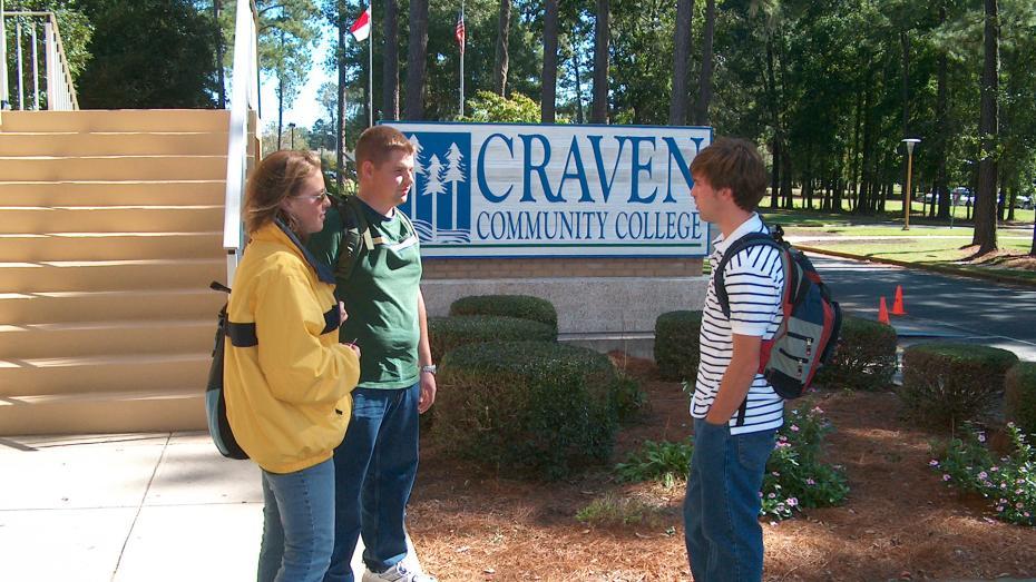 Three students standing outside by the Craven CC entrance sign in 2000s