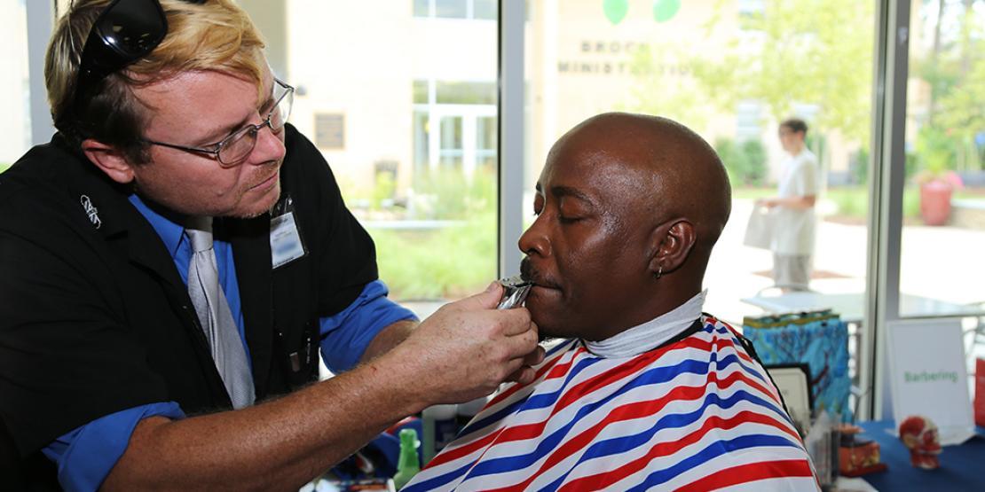 barbering student using clippers on instructor