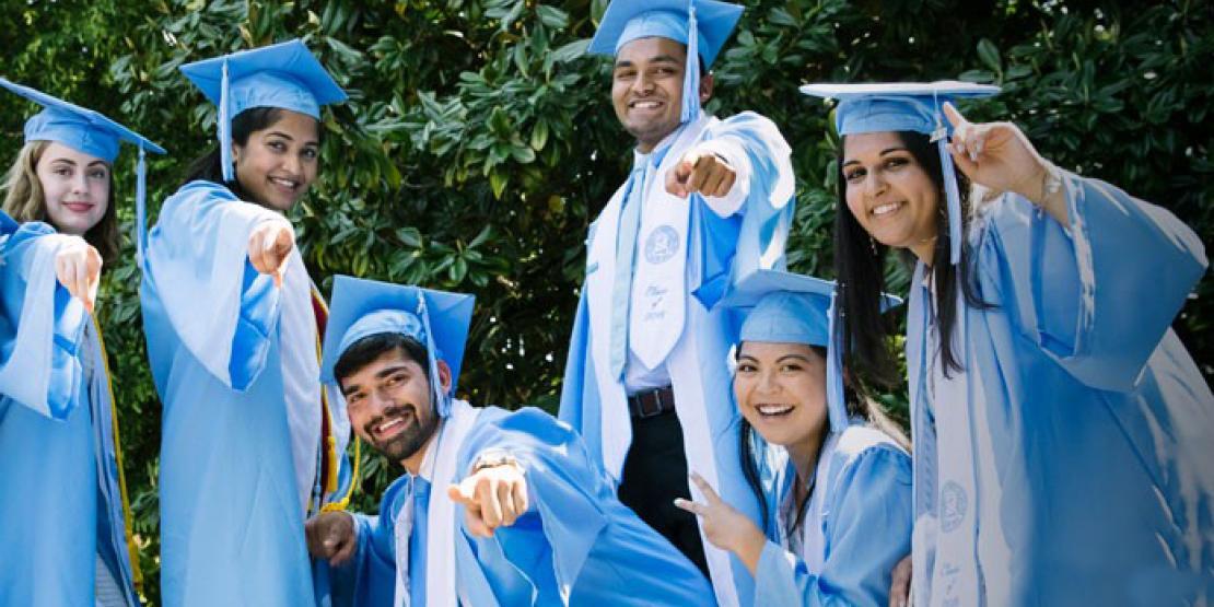 UNC Chapel Hill students in graduation garb outside