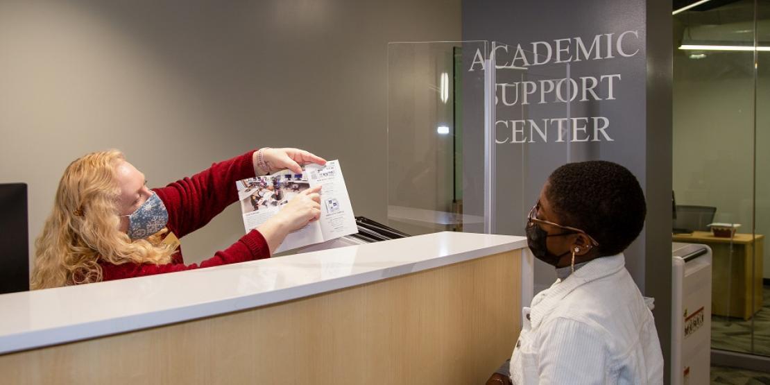 Marcy Latteman, Academic Support Center administrative assistant, talks to student Chayla Miller about tutoring services. The newly renovated space is located in Ward Hall on the New Bern campus.