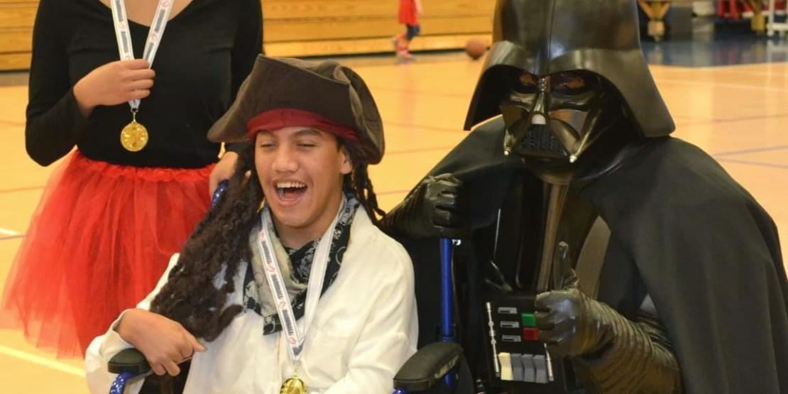 ​​​​​​​Craven CC student James Seay gives a thumbs up as he hands out medals during a Special Needs Baseball League award ceremony.