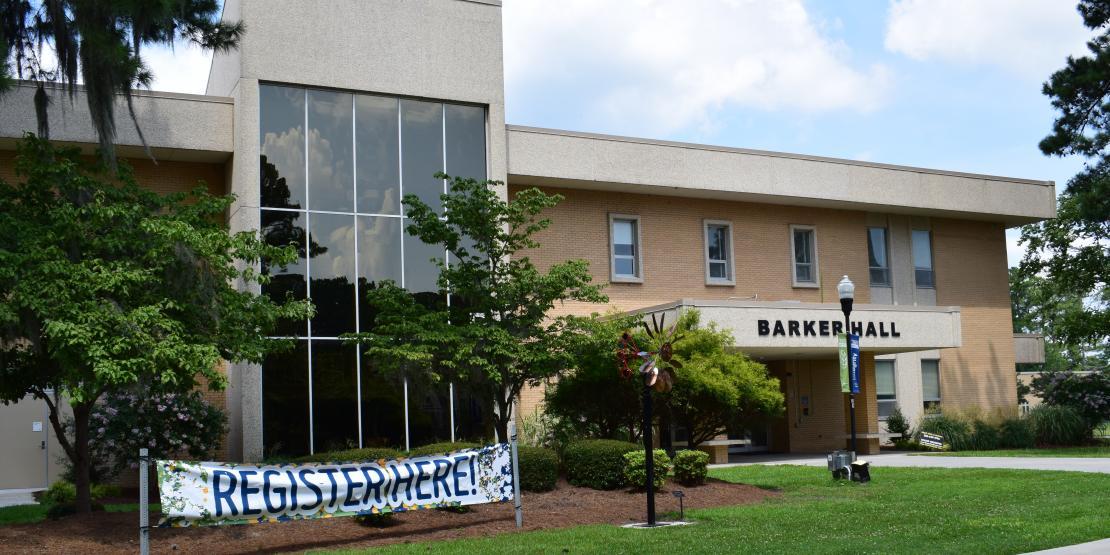 exterior front of Barker Hall with Register Here banner