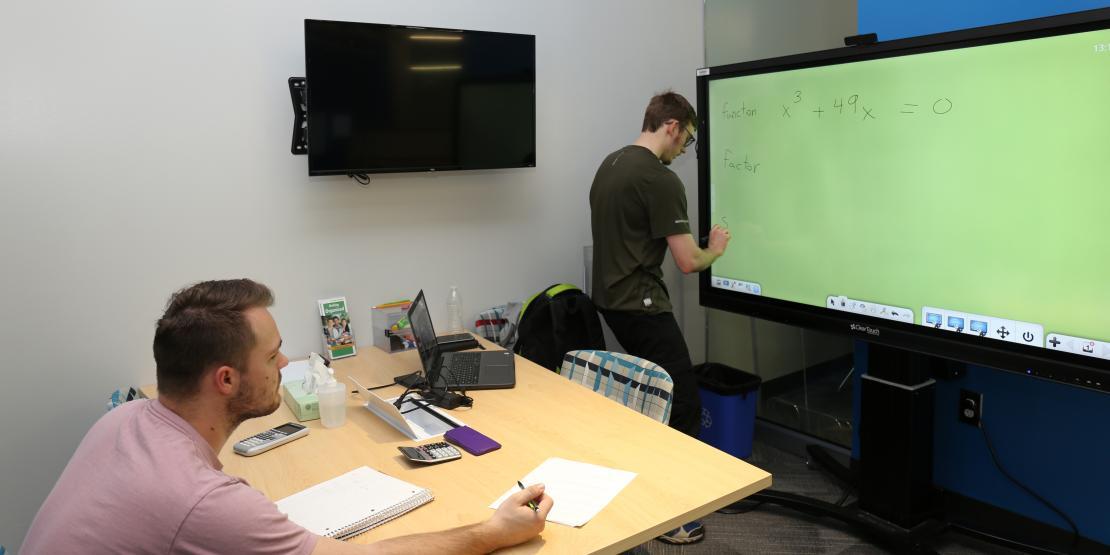 tutor helping student with math in academic support center