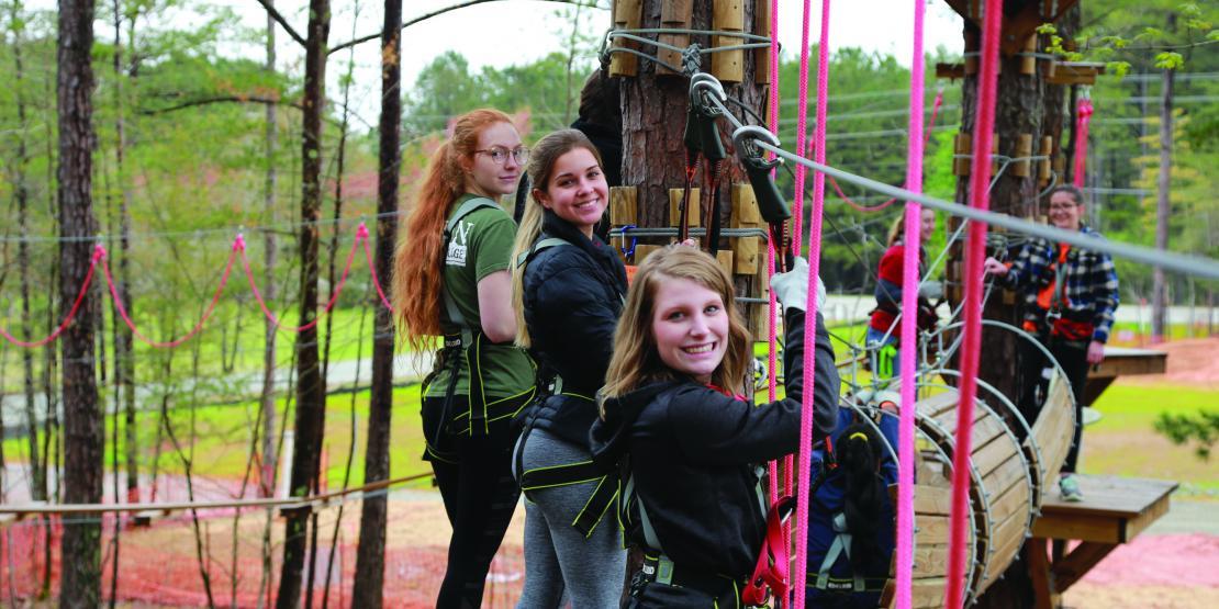 Students standing on a swinging bridge.