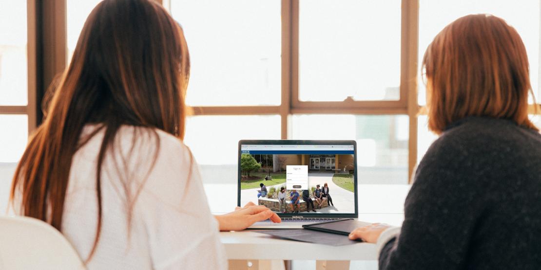 two female students logging into to school laptop