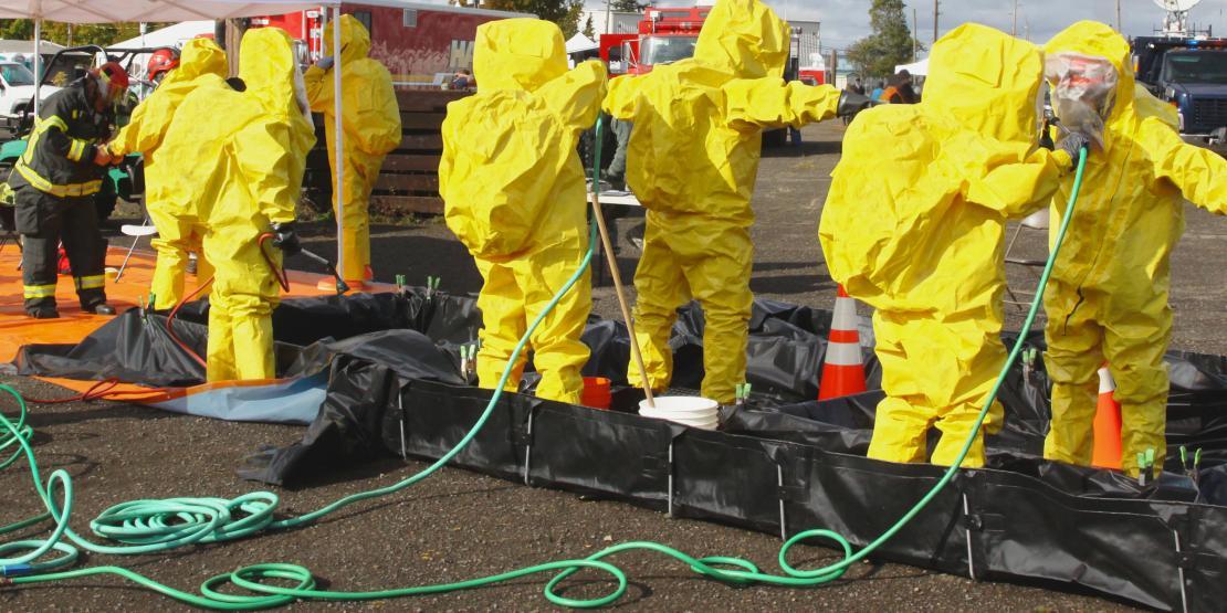 A group of first responders wearing yellow hazmat suits
