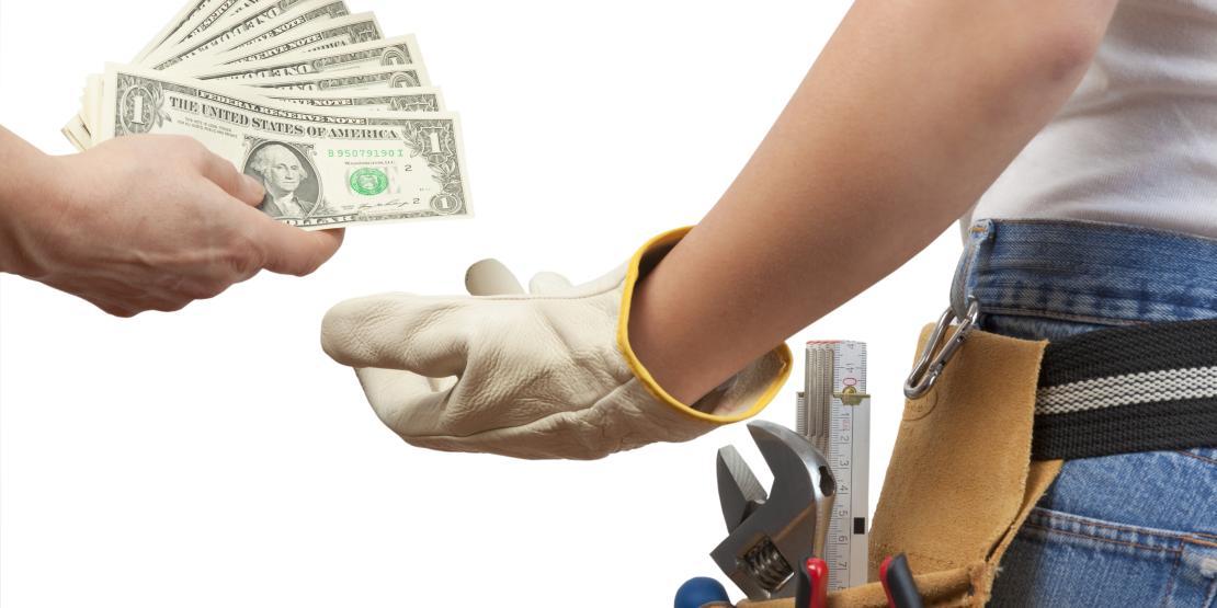 worker wearing tool belt is handed cash