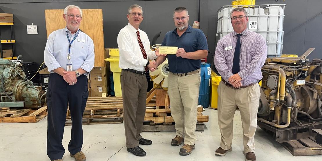 Craven CC President Dr. Ray Staats, second from left, receives a scholarship donation from Gregory Poole Equipment Company Technical Services Manager John Adamof. Also pictured are Volt Center Dean Eddie Foster (far left) and Vice President for Students Dr. Gery Boucher.
