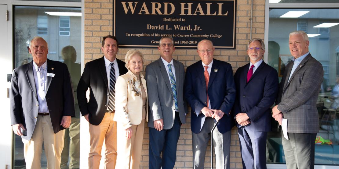 David L. Ward, Jr. is honored with an unveiling of the new signage for Ward Hall during a dedication ceremony on Feb. 21. The longtime Craven CC supporter served as the college's general counsel for over 51 years. Pictured L-R: Craven CC Trustee Bill Taylor, Trustee Chair Whit Whitley, past Trustee Carol Mattocks, Craven CC President Dr. Ray Staats, David Ward, past Craven CC President Scott Ralls, and Trustee Kevin Roberts.