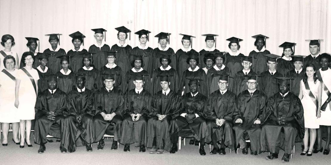 Black and white photo of graduates in caps and gowns