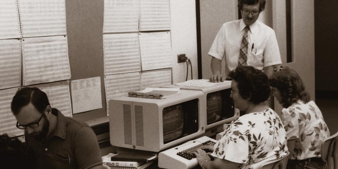 Teacher and students in computer lab in 1970s