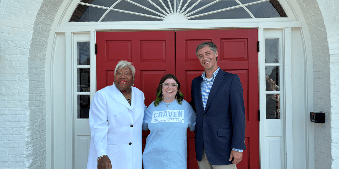 Foundation Campus Campaign Co-Chairs for 2024-2025 stand in front of red double doors