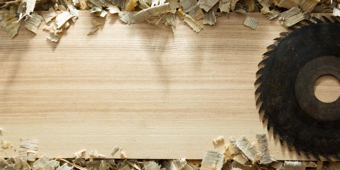 Wood plank with wood shavings and circular saw blade