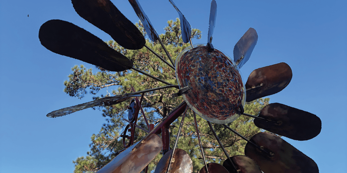 Metal and glass sculpture resembling a windmill