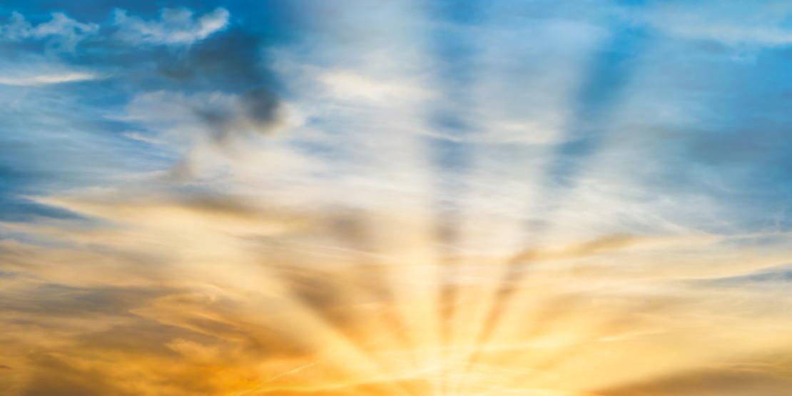 Beautiful dramatic sunset with sun rays and clouds