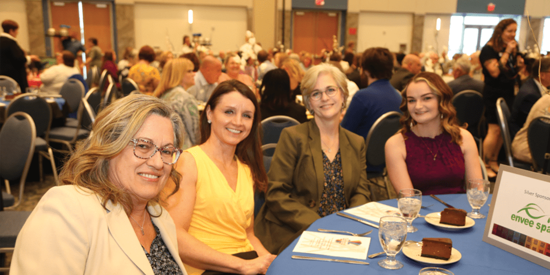 Four female guests sitting at a table during a Community Fabric Awards event
