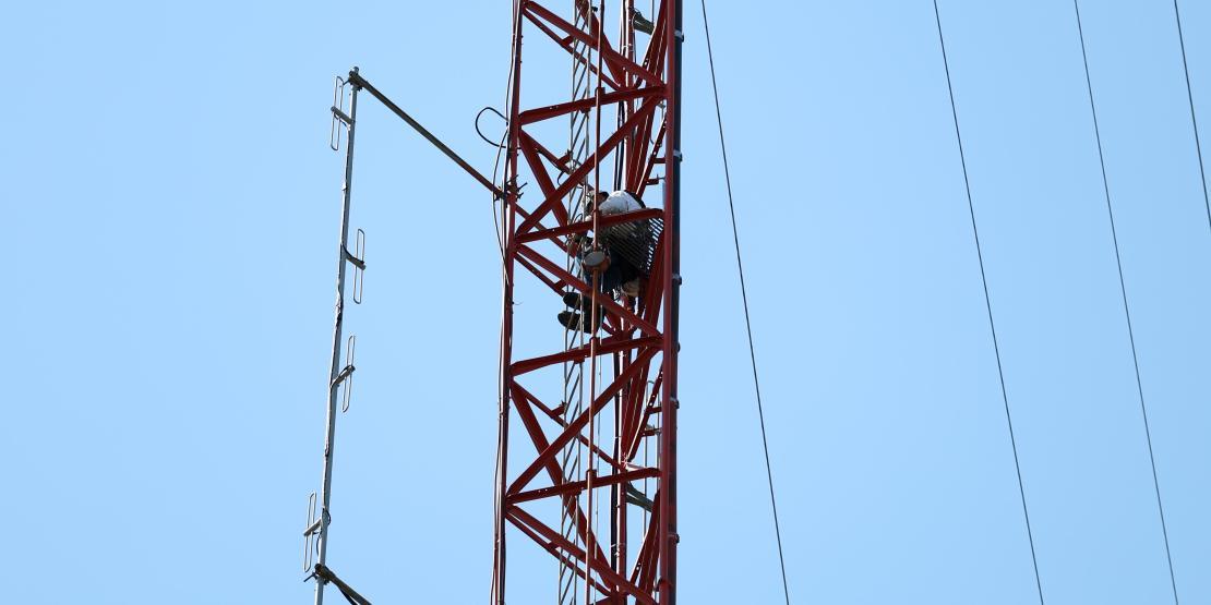 climber stands on antenna