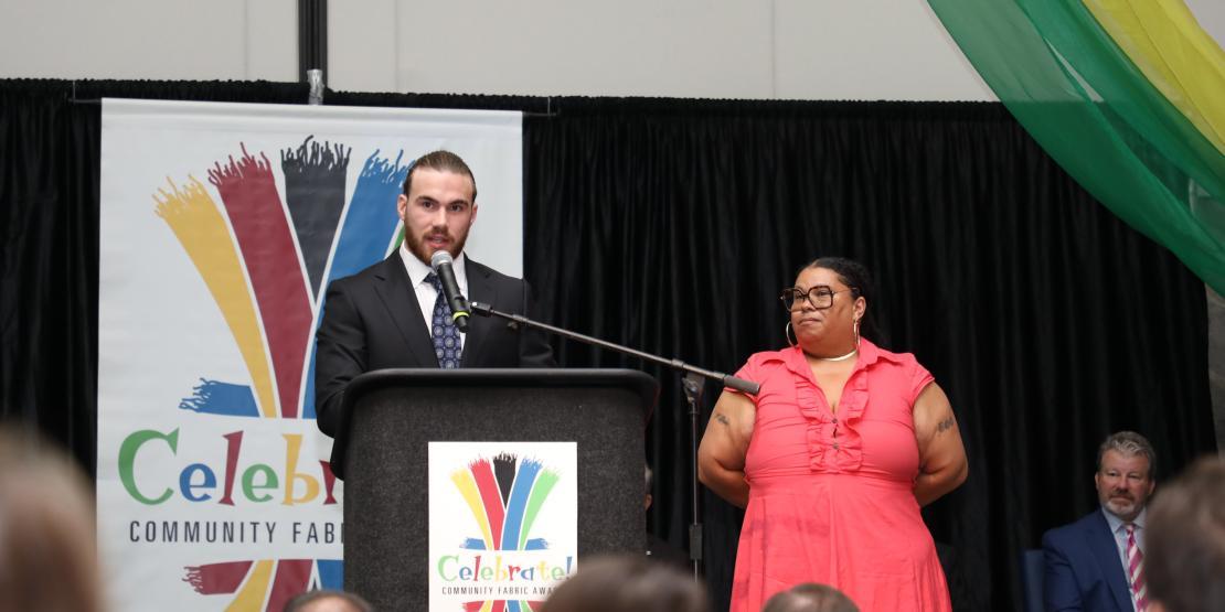 man speaks at microphone podium