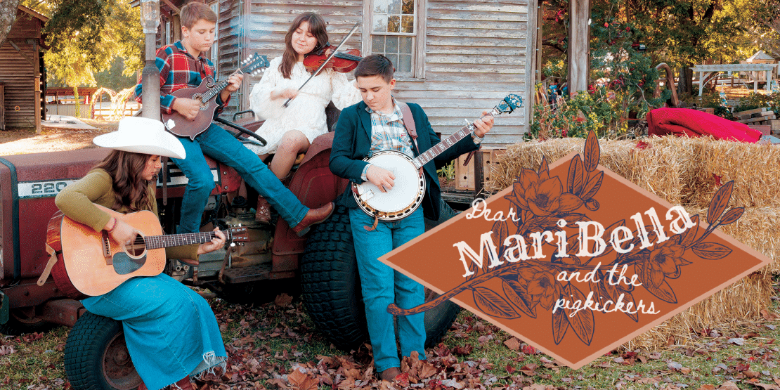 Four siblings playing music together in a country area