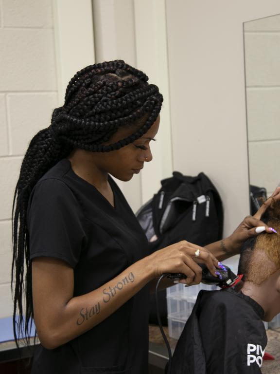 Cosmetology student practices shaving hair