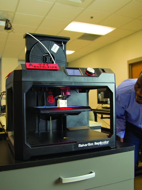Student examines 3-D printer