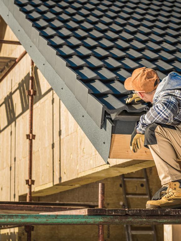 Construction worker inspects roof