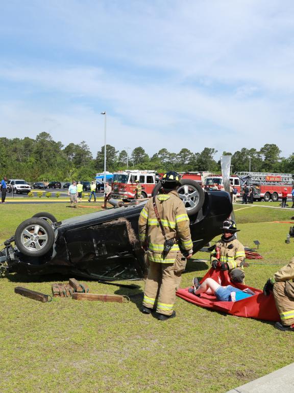 Firefighters next to upside down car during casualty drill