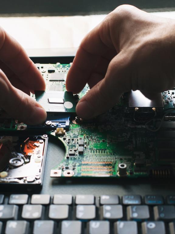 Person works on piecing together laptop components