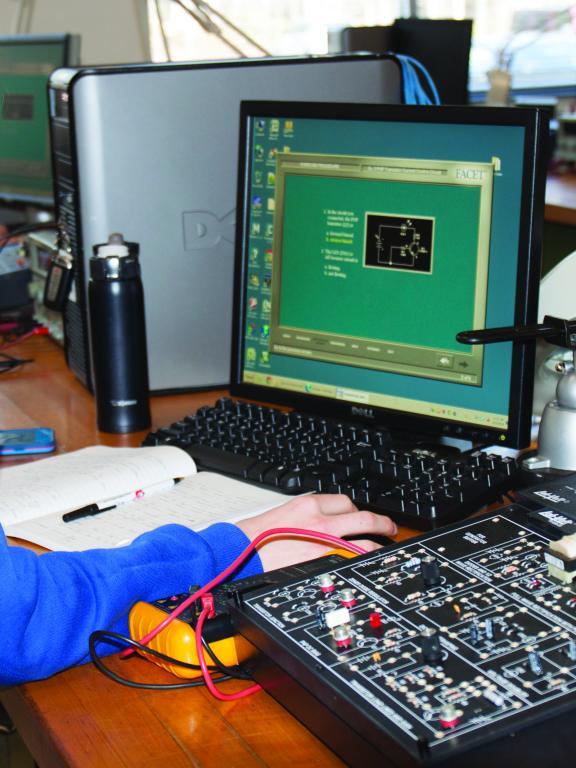 Female mechatronics student works on computer at desk