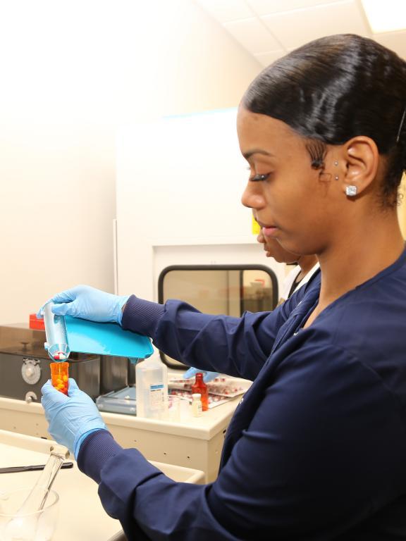 Pharmacy technician student practices dispensing pills