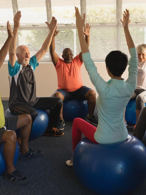 Woman leading group of seniors in exercise activity