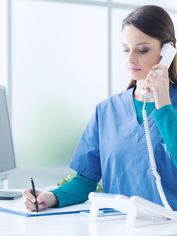 Nurse on phone by computer