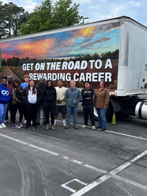 CDL program graduates stand in front of truck
