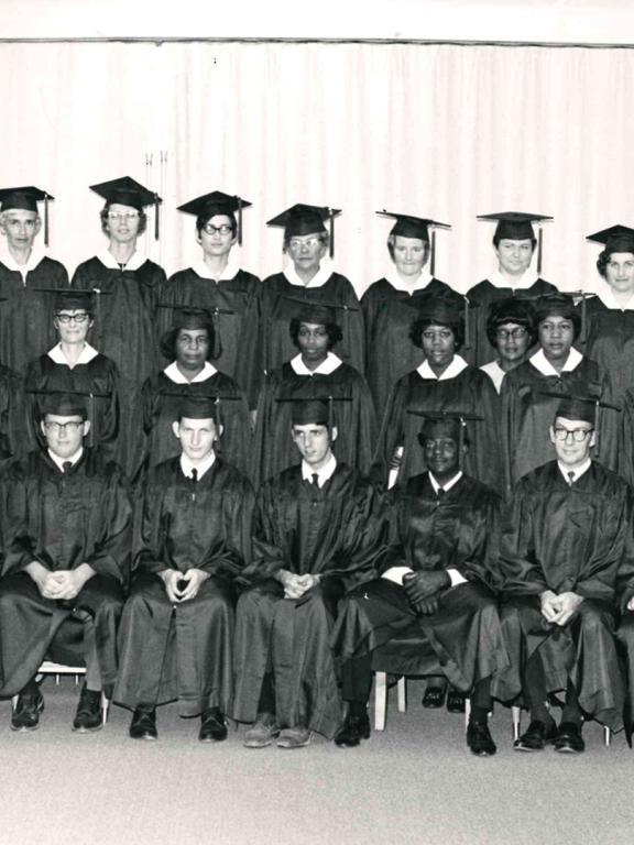 Black and white photo of graduates in caps and gowns