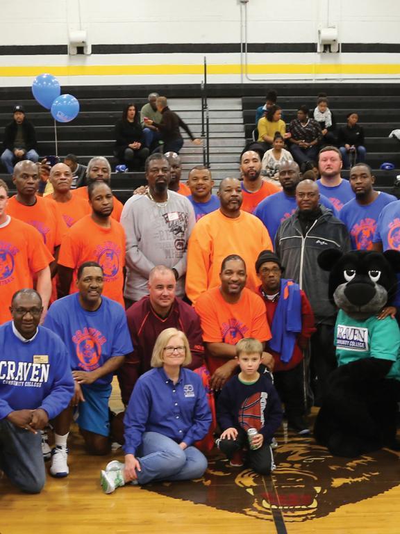 College employees on basketball court with Knight the Panther mascot in 2010s