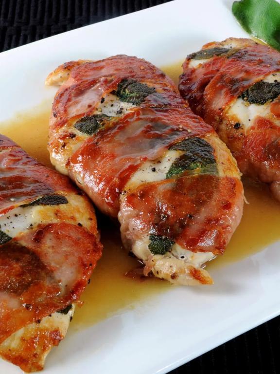 Chicken Saltimbocca on white plate with green garnish