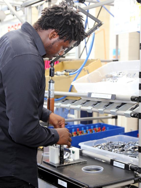 Male student works on mock assembly line