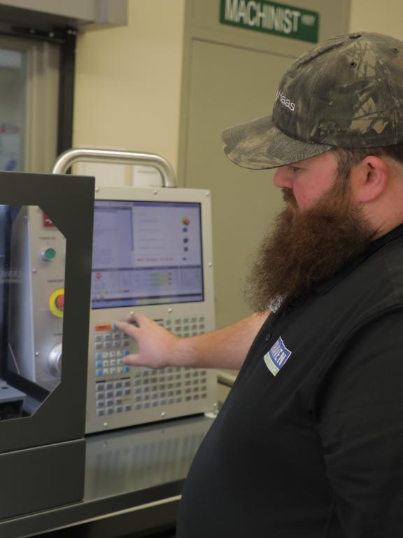 Computer-integrated machining instructor uses machine