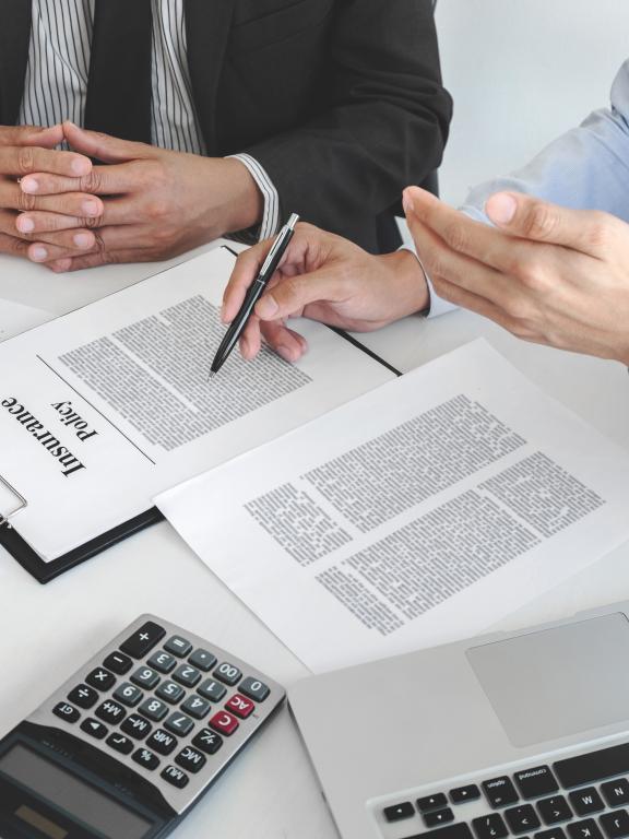 Insurance agent explaining insurance policy to customer in office.