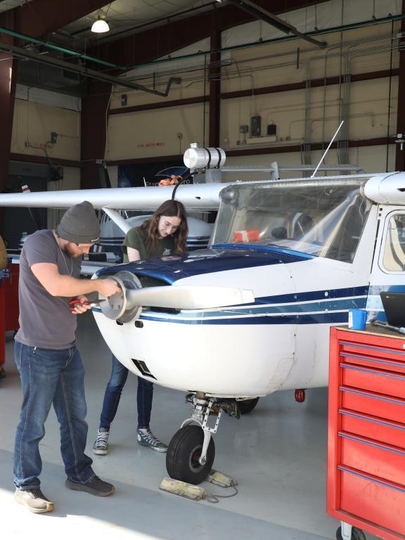 Students in the Havelock aviation program work on inactive planes in the hangar