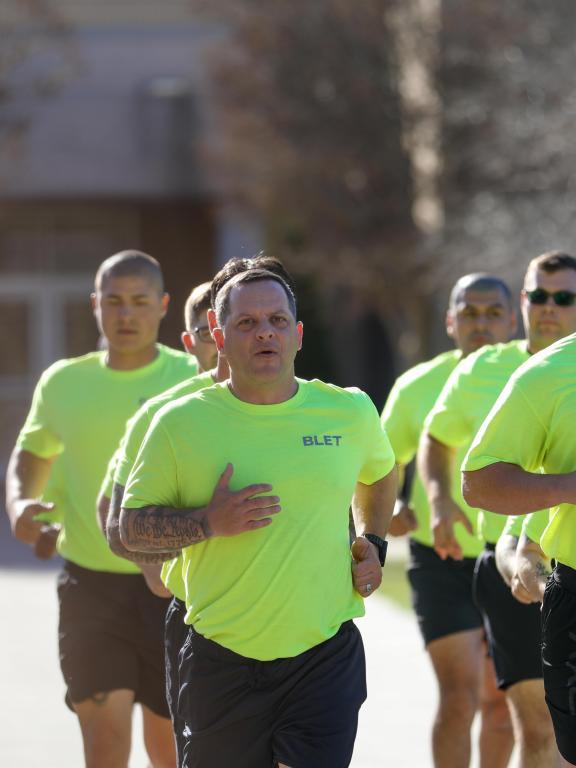 Basic Law Enforcement Training students run together outdoors during physical training.