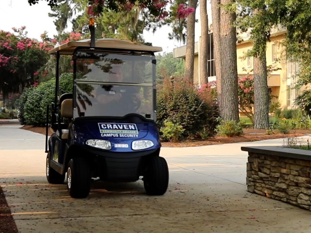 Campus Security officer driving golf cart on campus
