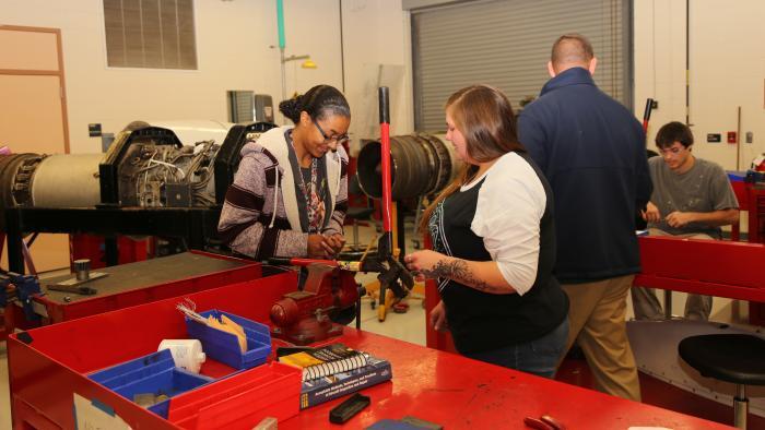 Aviation Systems Technology powerplant students look at parts